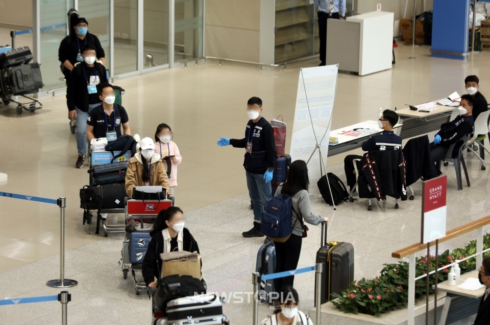 정부와 방역당국이 미국발 입국자 전체를 대상으로 입국 후 3일 이내에 신종 코로나바이러스 감염증(코로나19) 진단검사를 실시하기 시작한 13일 인천국제공항에서 미국발 입국자들이 육군 현장지원팀과 공항 관계자들로부터 안내 받고 있다. ⓒ뉴시스