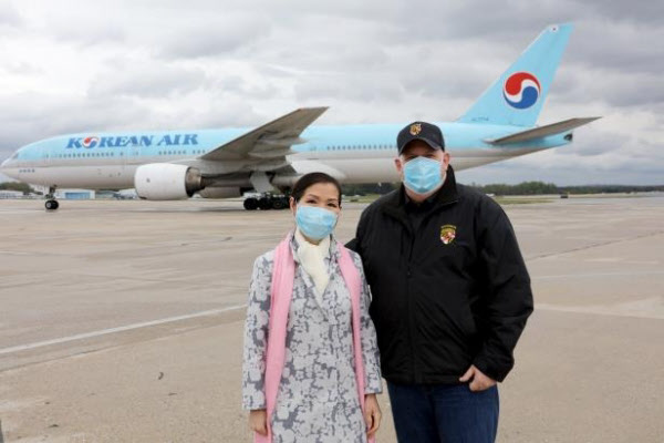 래리 호건(오른쪽) 미국 메릴랜드 주지사와 한국계 미국인 아내인 유미 호건이 18일(한국 시각) 볼티모어-워싱턴 국제공항에서 코로나 바이러스 진단 키트가 실린 대한항공 여객기를 뒤로 하고 촬영에 응하고 있다.ⓒ래리 호건 트위터 캡처