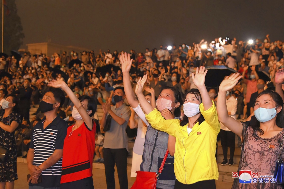 북한 조선중앙통신이 제공한 사진에 27일 평양에서 '조국 해방전쟁 67주년' 기념 불꽃놀이가 열려 코로나19 확산 예방을 위해 마스크를 쓴 평양 시민들이 이를 바라보며 환호하고 있다.ⓒap