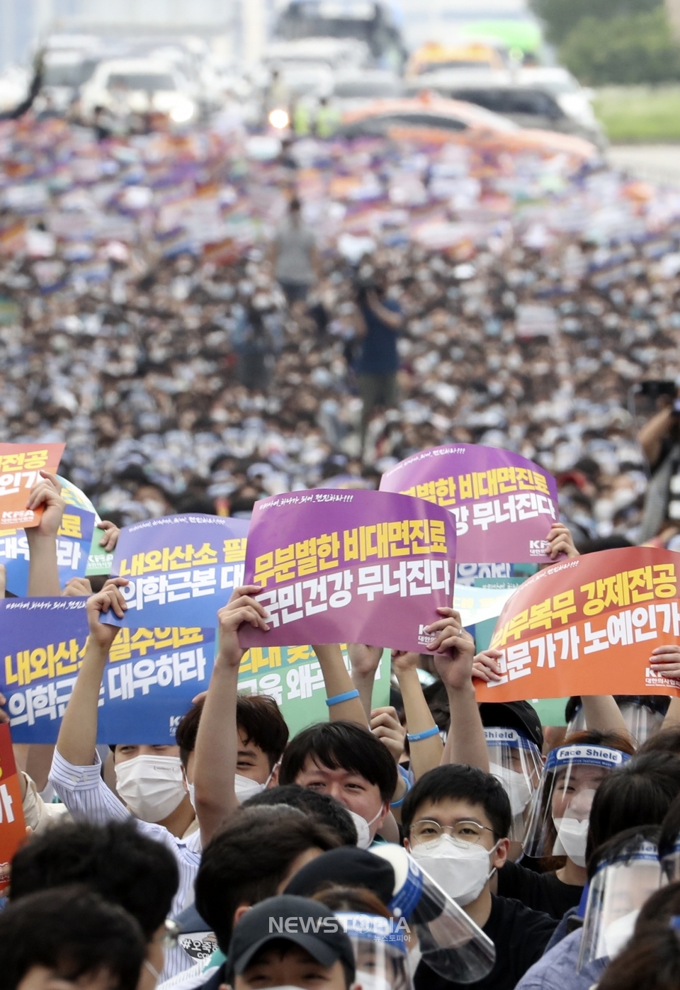 14일 서울 영등포구 여의대로에서 대한의사협회 주최로 열린 의료 4대악 정책추진 반대 전국 의사 총파업 궐기대회에 참석한 의사들이 피켓을 들고 있다. ⓒ뉴시스