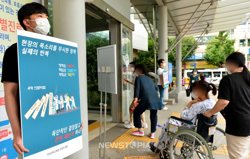 26일 오전 광주 동구 학동 전남대병원 앞에서 한 전공의가 의대 정원 확대 등에 반대하는 손팻말 시위를 하고 있다.ⓒ뉴시스