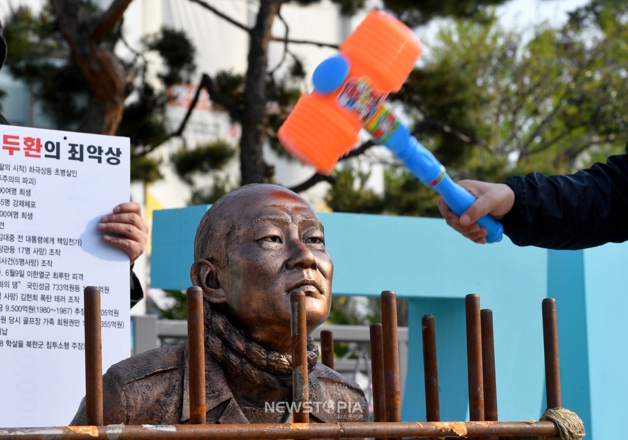5·18 3단체(유족회·부상자회·구속부상자회)가 25일 광화문 광장에 설치돼 있던 전두환 동상을 광주로 옮겨 동구 옛 전남도청 앞 5·18민주광장에 세웠다. 이날 5·18단체가 장난감 망치로 전씨 동상을 때리고 있다. 5·18단체는 고 조비오 신부의 명예를 훼손한 혐의로 형사재판을 받는 전두환씨가 오는 27일 광주 법정에 출석할 것으로 관측돼 재판 당일 광주지법 앞으로 동상을 옮겨 엄벌과 사죄를 촉구한다.ⓒ뉴시스