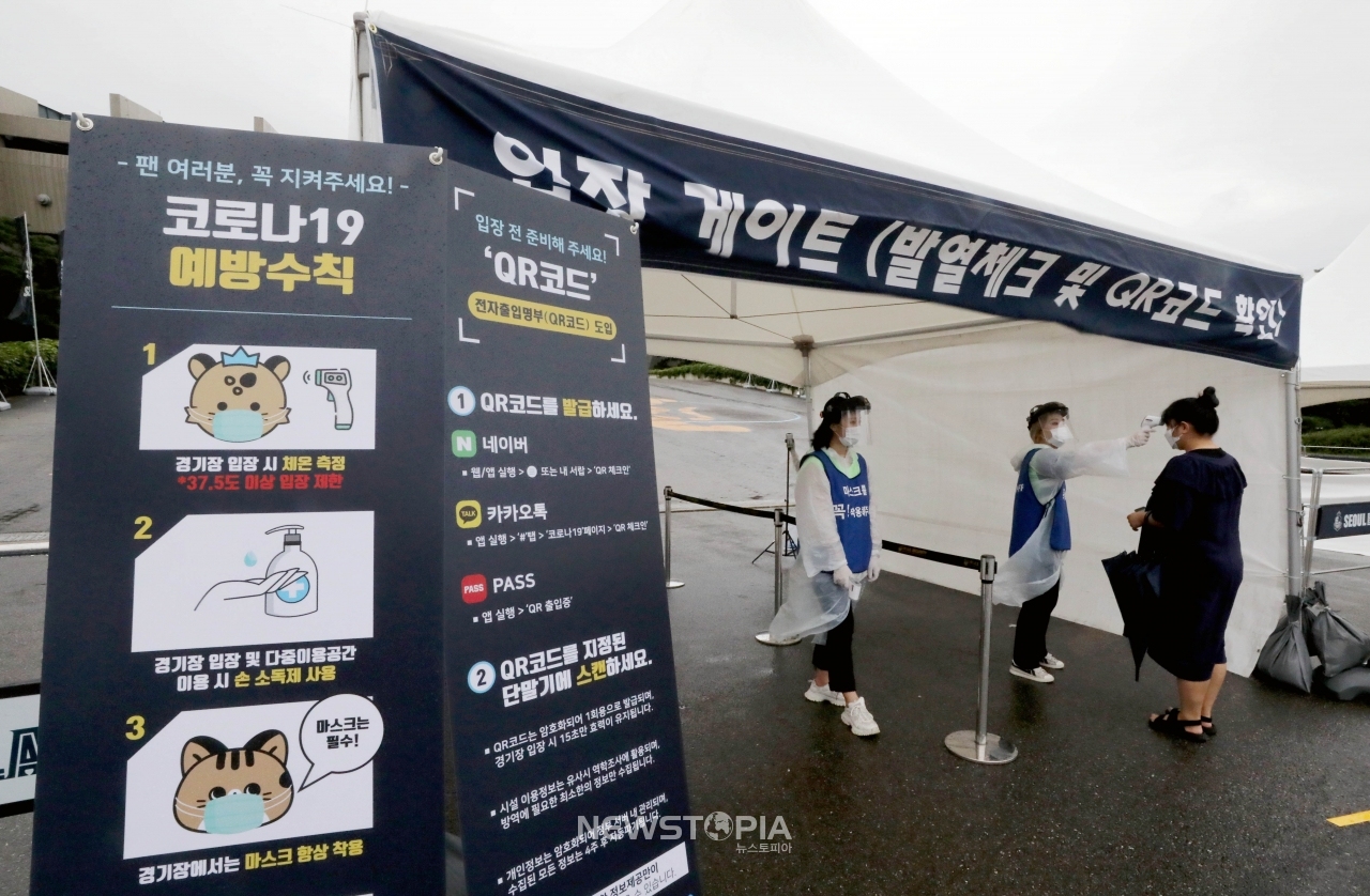 2일 오후 서울 송파구 잠실올림픽주경기장에서 열린 서울이랜드FC와 부천FC1995의 경기를 찾은 관중이 입장에 앞서 체온 측정하고 있다. ⓒ뉴시스