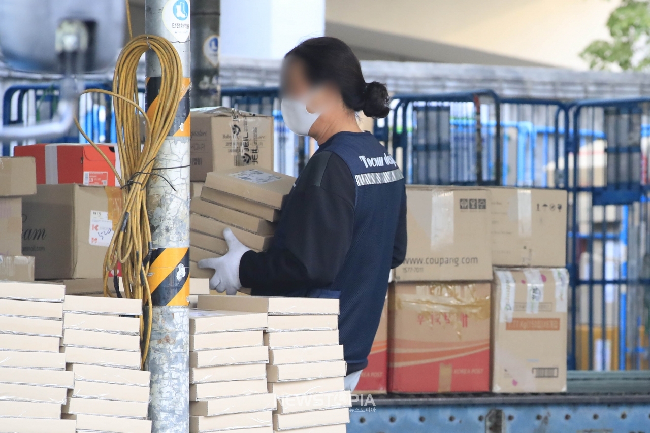 문재인 대통령이 택배노동자 과로사 문제에 대해 "더는 안타까운 일이 발생하지 않도록 특별히 대책을 서둘러주기 바란다"고 밝힌 20일 서울 시내의 한 물류센터에서 택배노동자가 물품을 나르고 있다. ⓒ뉴시스