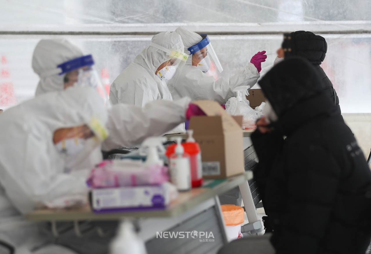 제주 지역에 강추위 기승을 부리고 있는 7일 제주시보건소 내 주차장 한 켠에 마련된 코로나19 선별진료소에서 의료진들이 검체 채취를 하고 있다.ⓒ뉴시스