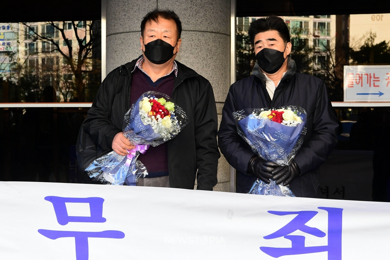 부산 '낙동강변 살인사건' 가해자로 몰려 21년간 억울한 옥살이를 한 최인철(왼쪽)씨와 장동익씨가 4일 오전 부산 연제구 부산고등법원에서 열린 재심 선고 공판을 통해 31년 만에 무죄를 선고받은 뒤 꽃다발을 들고 있다. (사진=국제신문 제공).