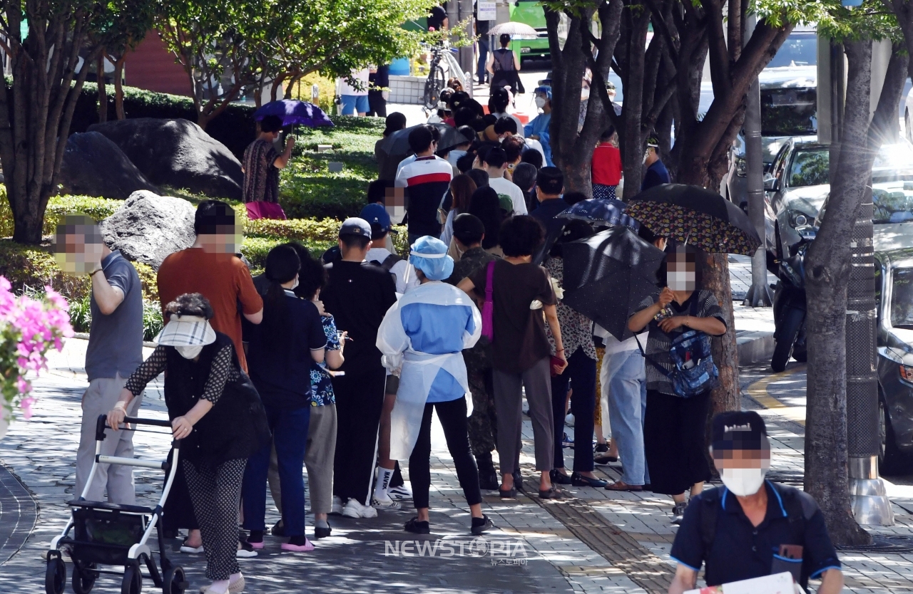 부산지역 코로나19 확산세가 심상치 않은 가운데 26일 오전 부산 남구보건소 선별진료소를 찾은 시민들이 진단검사를 받기 위해 길게 줄을 선 채 차례를 기다리고 있다. 이날 해당 보건소 주변으로 검사 대기 줄이 100m 가량 이어졌다.