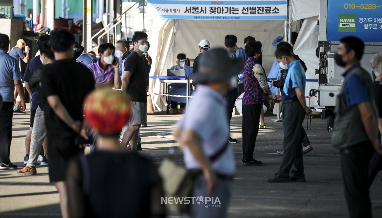 가락시장에서 코로나19 확진자가 잇따라 나오고 있는 12일 오전 서울 송파구 가락농수산물종합도매시장에 설치된 찾아가는 선별진료소를 찾은 시장 상인 및 시민들이 코로나19 검사를 받기 위해 줄 서 있다. ⓒ뉴시스