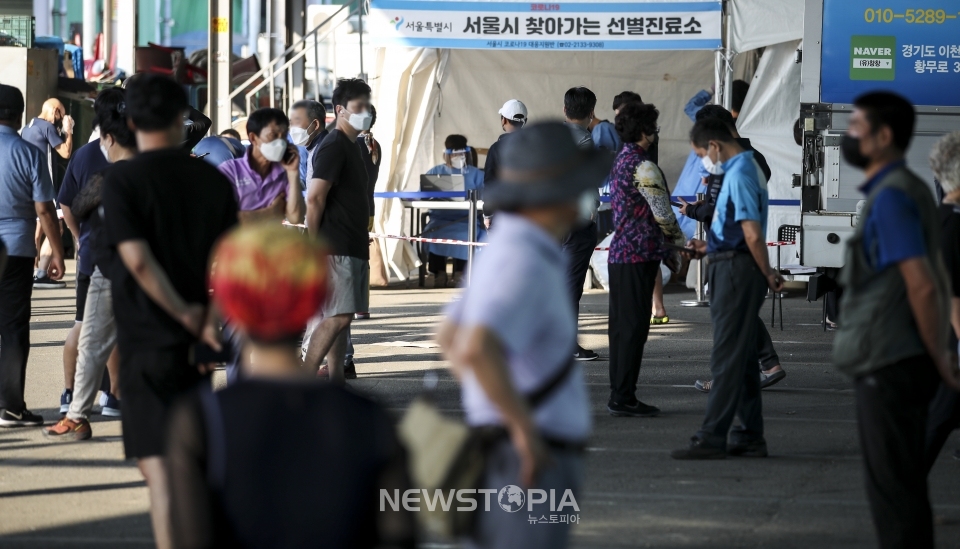 가락시장에서 코로나19 확진자가 잇따라 나오고 있는 12일 오전 서울 송파구 가락농수산물종합도매시장에 설치된 찾아가는 선별진료소를 찾은 시장 상인 및 시민들이 코로나19 검사를 받기 위해 줄 서 있다. ⓒ뉴시스