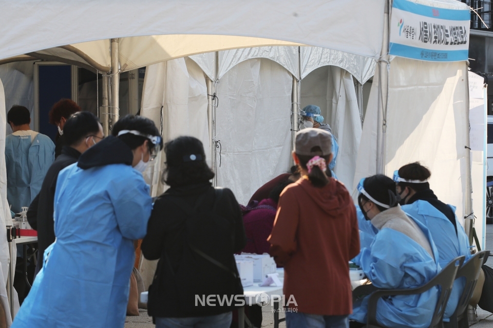 코로나19 신규 확진자가 1,190명으로 집계된 25일 오전 서울 종로구 흥인지문 인근에 설치된 찾아가는 선별진료소에서 시민들이 검사를 받기 위해 대기하고 있다. ⓒ뉴시스