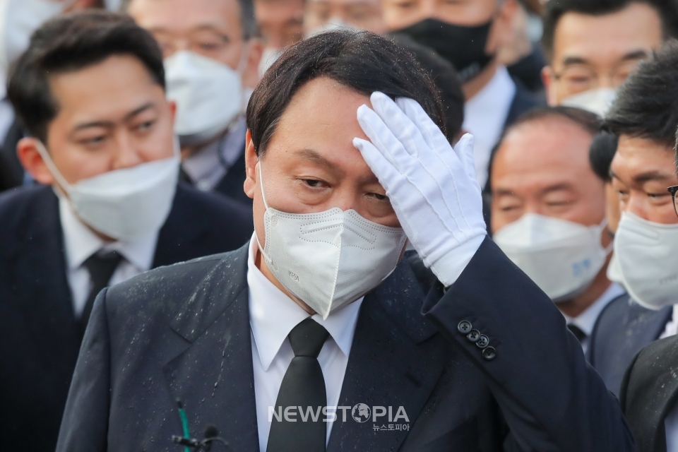 윤석열 국민의힘 대선후보가 10일 오후 광주 북구 운정동 국립5·18민주묘지 참배를 위해 이동하던 중 떨어지는 빗물을 손으로 닦고 있다. ⓒ뉴시스