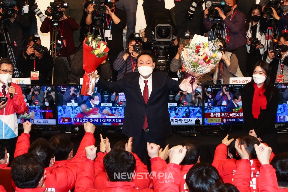 윤석열 대통령 당선인이 10일 새벽 서울 여의도 국회 도서관에 마련된 개표상황실을 찾아 당선 축하 꽃다발을 들어보이고 있다. ⓒ뉴시스