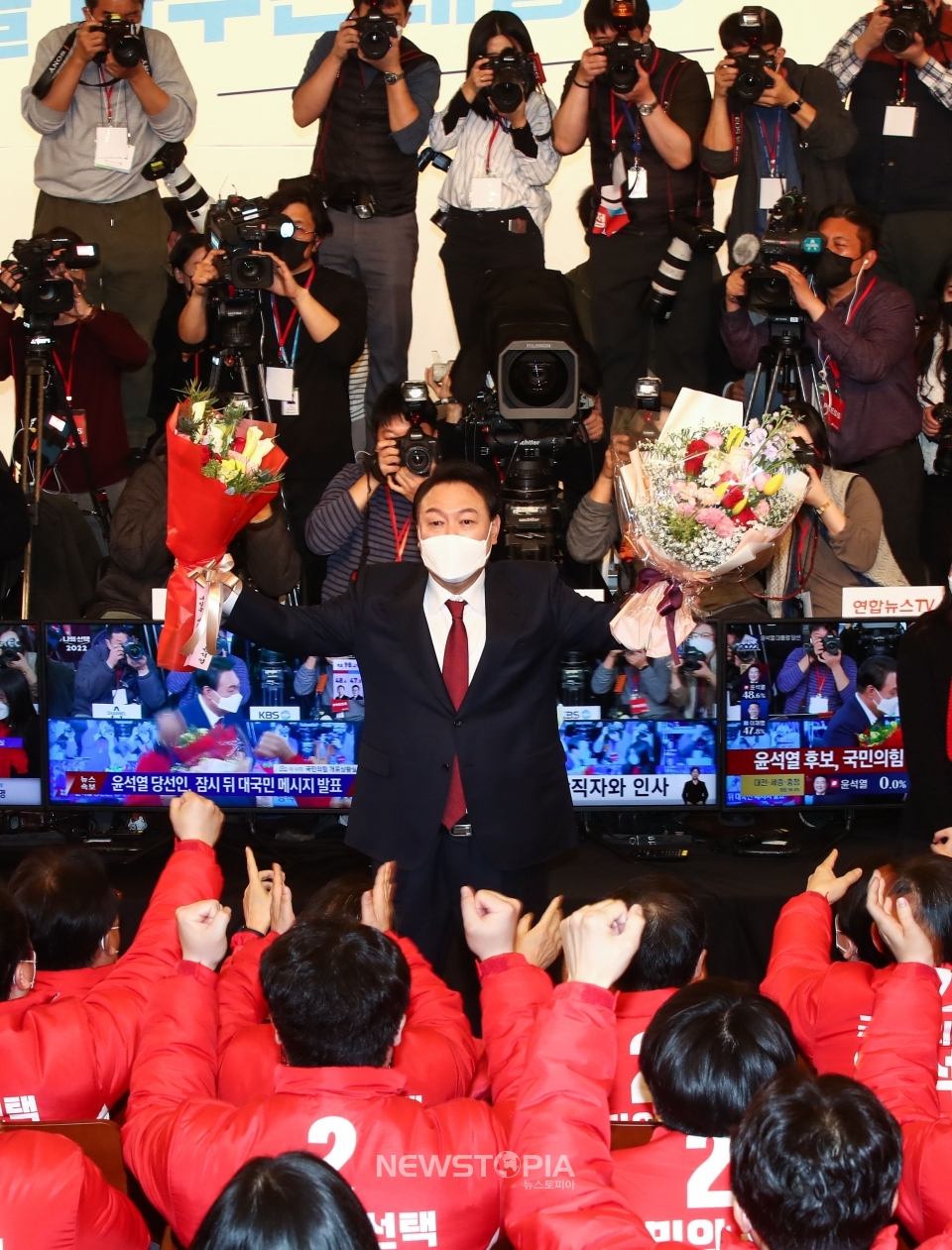 윤석열 대통령 당선인이 10일 새벽 서울 여의도 국회 도서관에 마련된 개표상황실을 찾아 당선 축하 꽃다발을 들어보이고 있다. ⓒ뉴시스