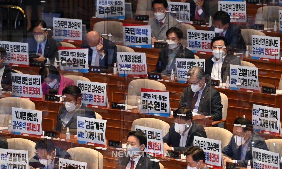 국민의힘 의원들이 27일 오후 서울 여의도 국회 본회의장에서 열린 본회의에서 '검수완박(수사·기소권 분리)' 법안 상정에 반대하는 피켓을 자리에 붙여놓고 있다.ⓒ뉴시스