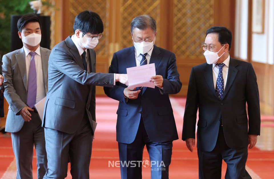 문재인 대통령이 4일 청와대 본관에서 백서 발간 기념 국정과제위원회 초청 오찬에 앞서 열린 백서 전달식에 입장하며 탁현민 의전비서관과 대화하고 있다.ⓒ뉴시스