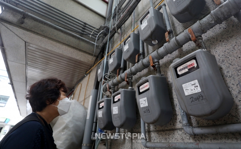 내달 가스요금이 오르며 오는 10월에는 전기요금과 가스요금이 동반 인상될 예정이다. 14일 오후 서울 시내 한 건물 뒤에서 시민이 가스계량기를 살펴보고 있다.