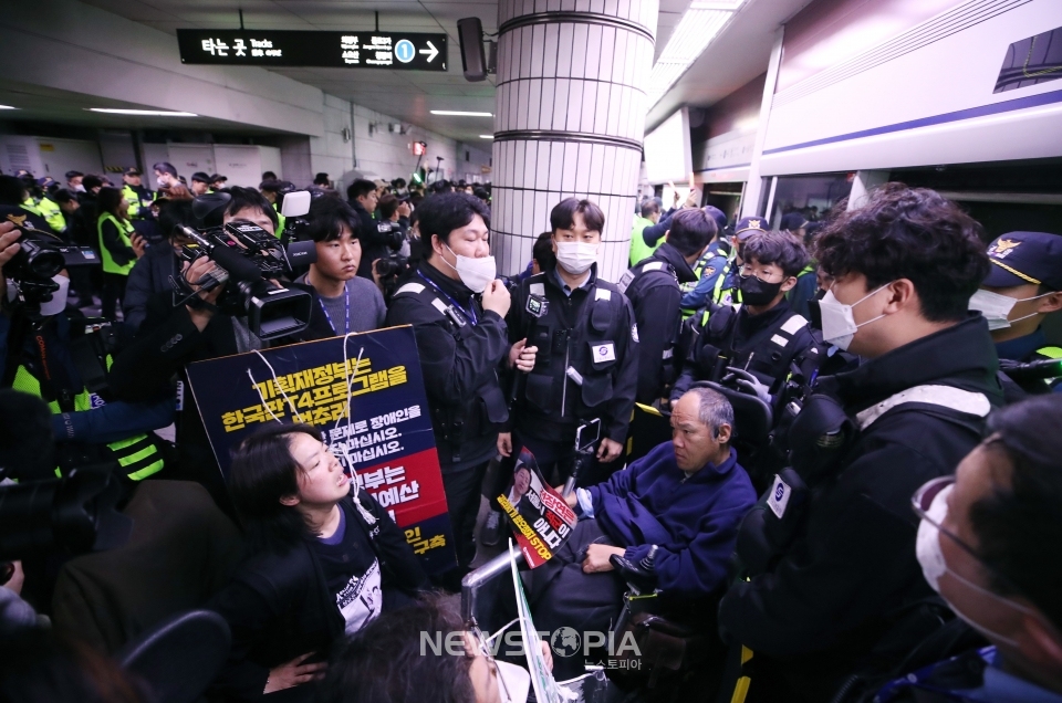 전국장애인차별철폐연대(전장연)가 23일 서울 지하철 1호선 시청역에서 오세훈 서울시장 대화 촉구 출근길 지하철 탑승선전전을 한 뒤 지하철 탑승을 시도했지만, 이를 저지하는 경찰과 지하철 보안관에 막혀 대치하고 있다.ⓒ뉴시스