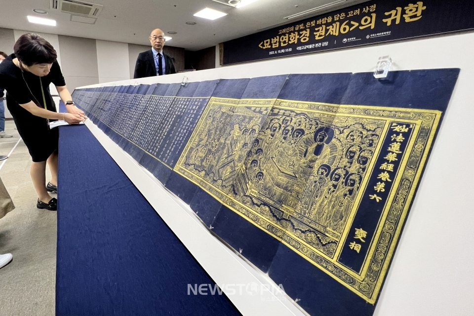 문화재청 직원들이 15일 서울 종로구 국립고궁박물관에서 국외소재문화재재단을 통해 일본에서 환수한 고려 사경(寫經) '묘법연화경 권제6(妙法蓮華經 卷第6)' 언론 공개회를 준비하고 있다. 사경(寫經)은 불교 경전을 옮겨 적은 경전을 의미하는데, 본래 불교 교리를 전파하기 위해 제작되었으나 점차 발원(發願)을 통해 공덕(功德)을 쌓는 방편으로 여겨져 널리 제작되었다. '묘법연화경 권제6'은 감색(紺色) 종이에 경전의 내용을 금·은니(金·銀泥)로 필사하여 절첩본(折帖本)으로 만든 고려 사경(寫經)으로, 크기는 (접었을 때) 세로 27.6cm×가로 9.5cm, (펼쳤을 때) 가로 1,070cm, (두께) 1.65cm 이다.ⓒ뉴시스