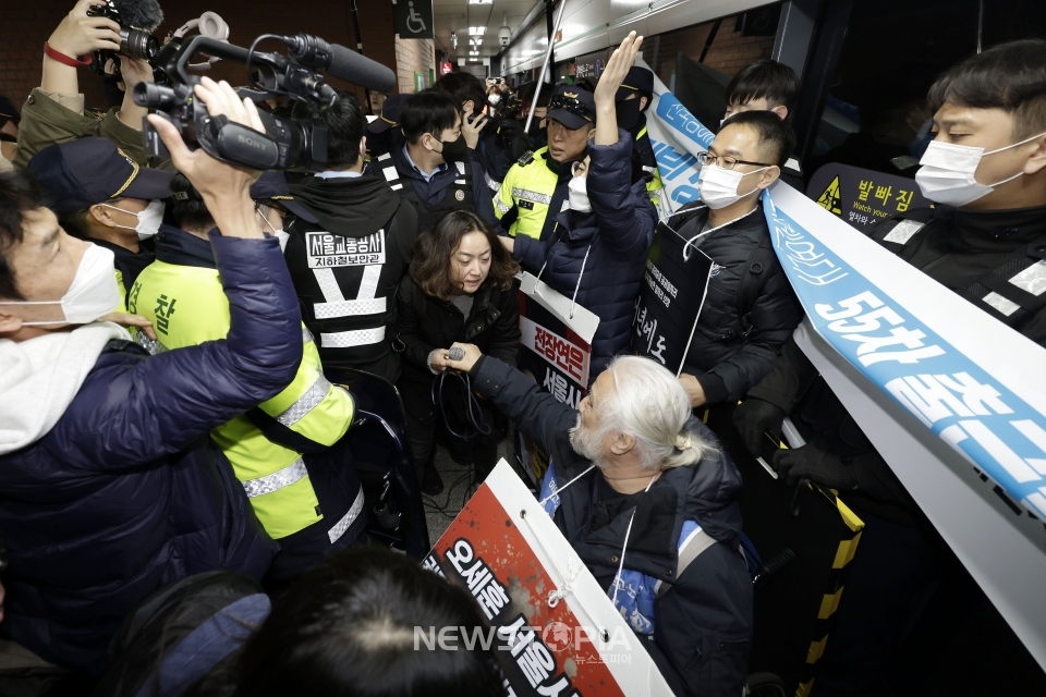 전국장애인차별철폐연대가 20일 서울 지하철 시청역에서 정부의 장애인 이동권 포함 증액예산안 반영 촉구 '출근길 지하철 시위'를 진행했다. 경찰이 전장연에 대해 철도안전법, 집시법 위반으로 채증 등을 실시하자 양측 간 충돌이 발생하고 있다. ⓒ뉴시스