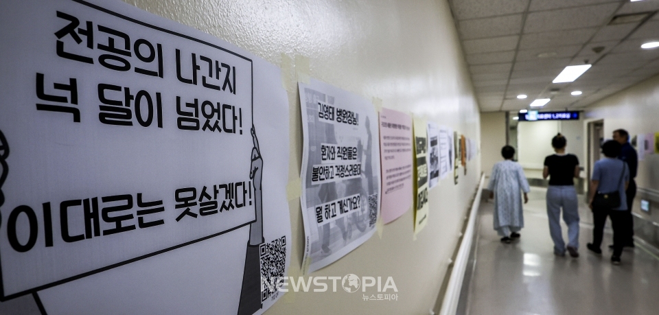 정부가 이르면 이번 주 미복귀 전공의 관련 대책을 발표할 것으로 알려진 가운데 7일 서울시내 대학병원에 붙은 전공의 집단행동 중단을 촉구하는 인쇄물 옆으로 환자와 보호자들이 이동하고 있다. ⓒ뉴시스