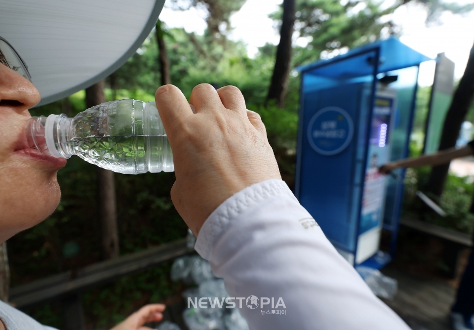 한 등산객이 생수 나눔 냉장고를 이용하고 있다.ⓒ뉴시스